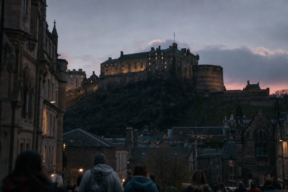 Edinburgh Castle on its volcanic rock, seen from the Royal Mile at dusk